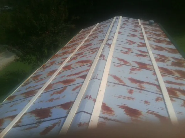 Rusted metal roof panels with new wood purlins before replacement — Storm Damage Roof Repair in Juda by Roofing Brothers