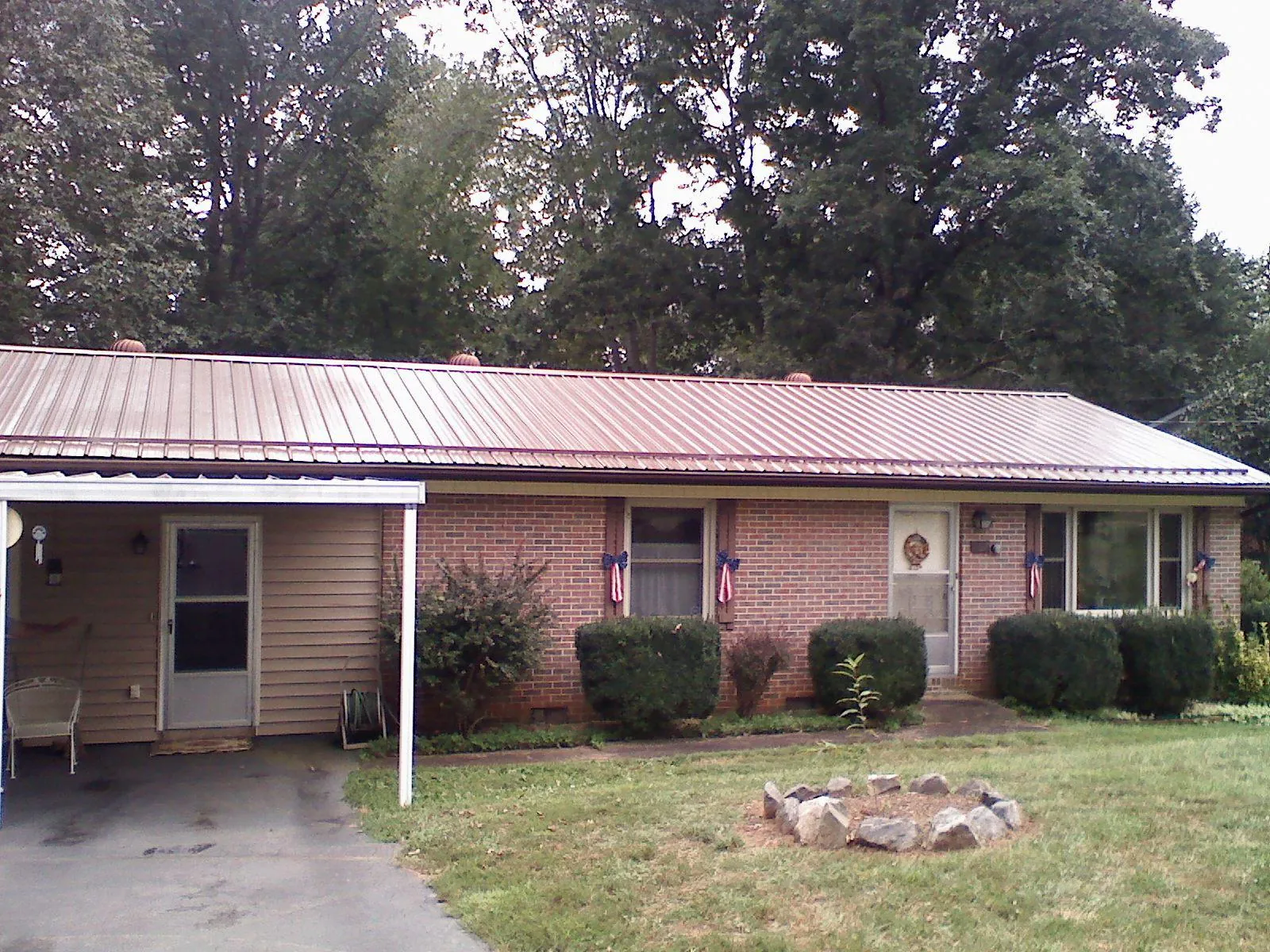 Bronze metal roof and carport on a brick ranch home — Roof Repair work by our crew in Juda