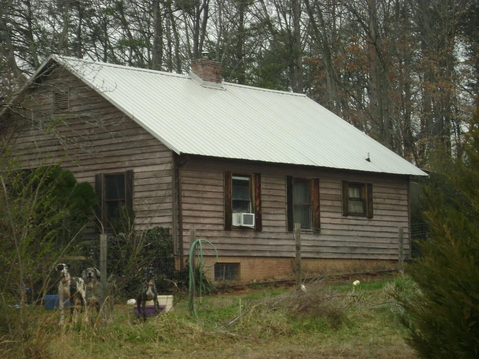 White metal roof on an old wood sided farmhouse, from a Metal Roof Installation job in Juda
